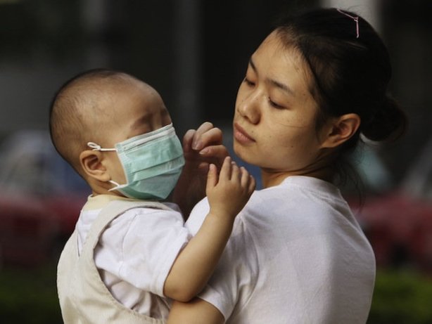 A baby in China wears a protective face mask (AP/Kin Cheung)